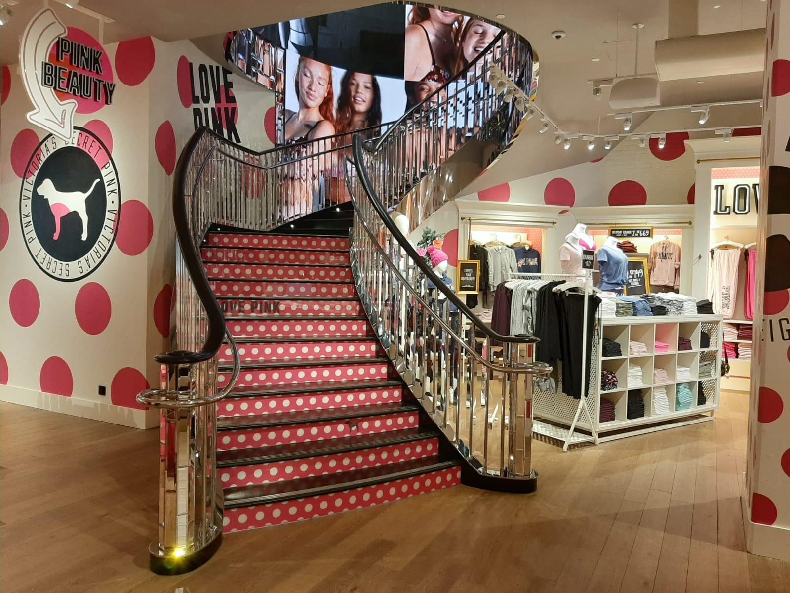 Scala curva e superfici riflettenti in uno spazio retail